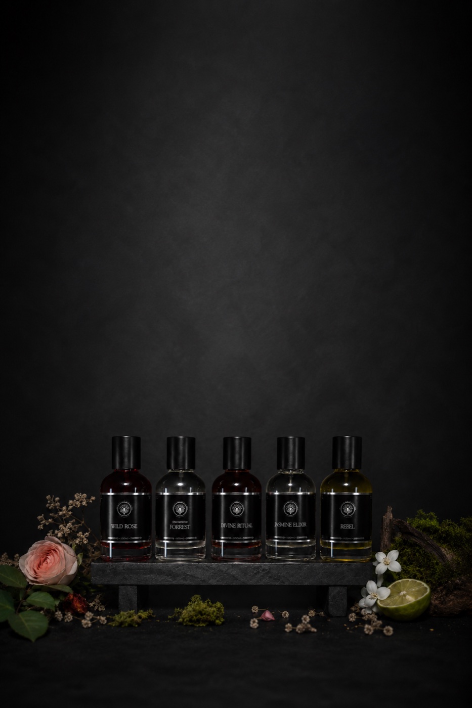 Soulchemy perfumes — five bottles on a stone bench with botanicals